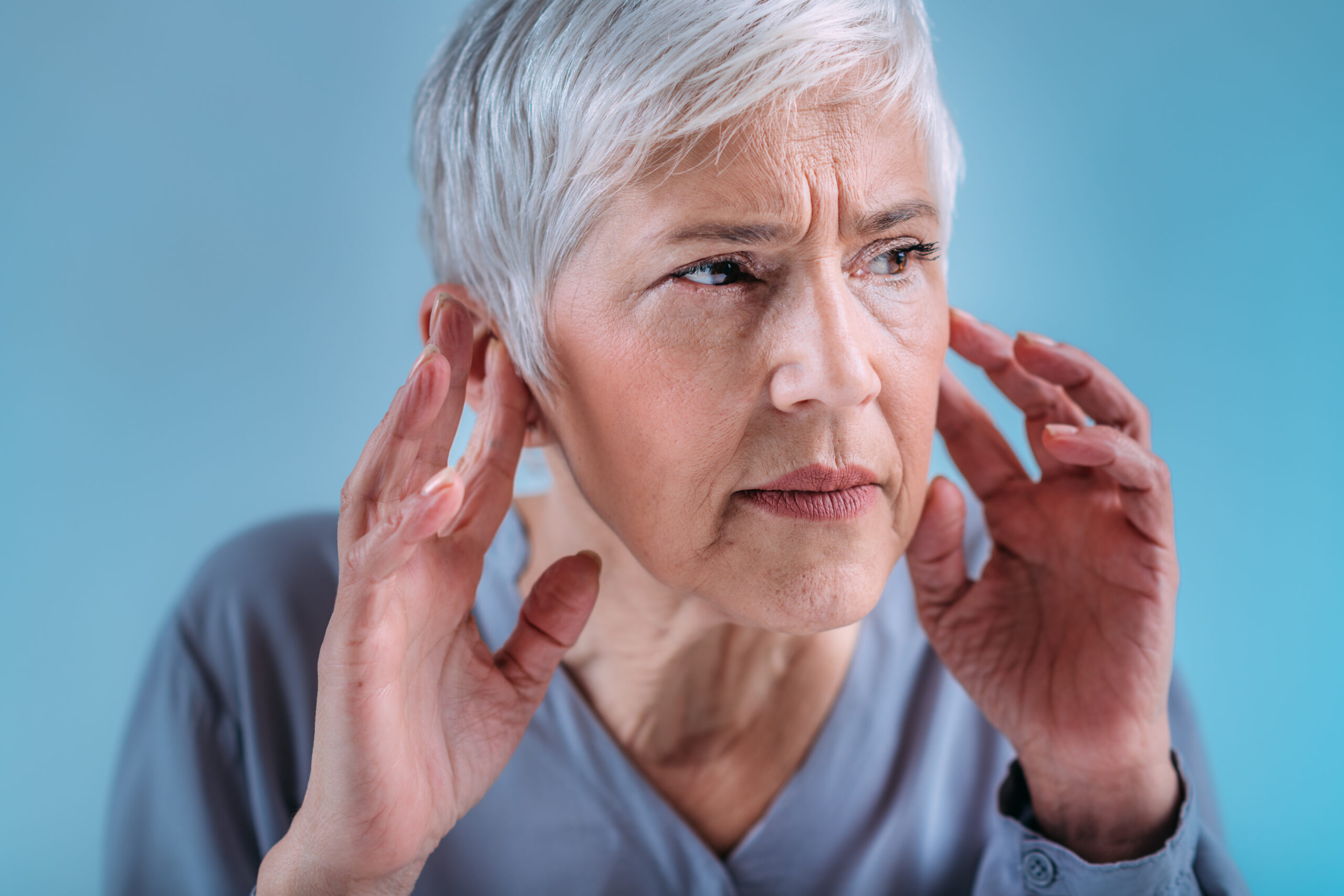 Hearing loss. Senior woman with symptoms of hearing loss.