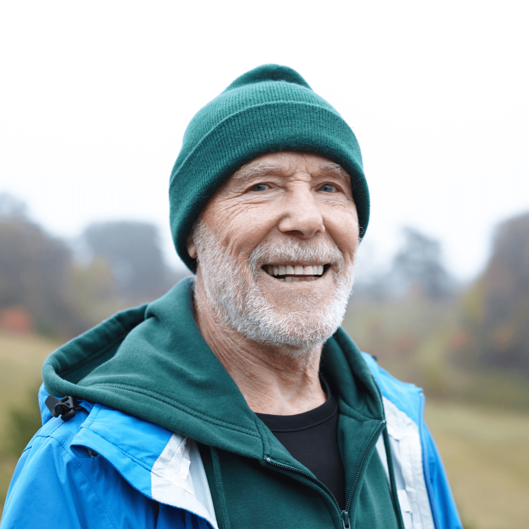 Happy older man outdoors in nature on a hike