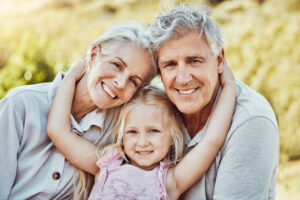 Grandparents, girl and smile portrait in a family outdoor park happy about a picnic. Children, happiness and kids with elderly grandparent in garden or backyard smiling and bonding together in nature.