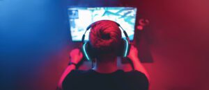 Background professional gamer playing tournaments online games computer with headphones, red and blue.